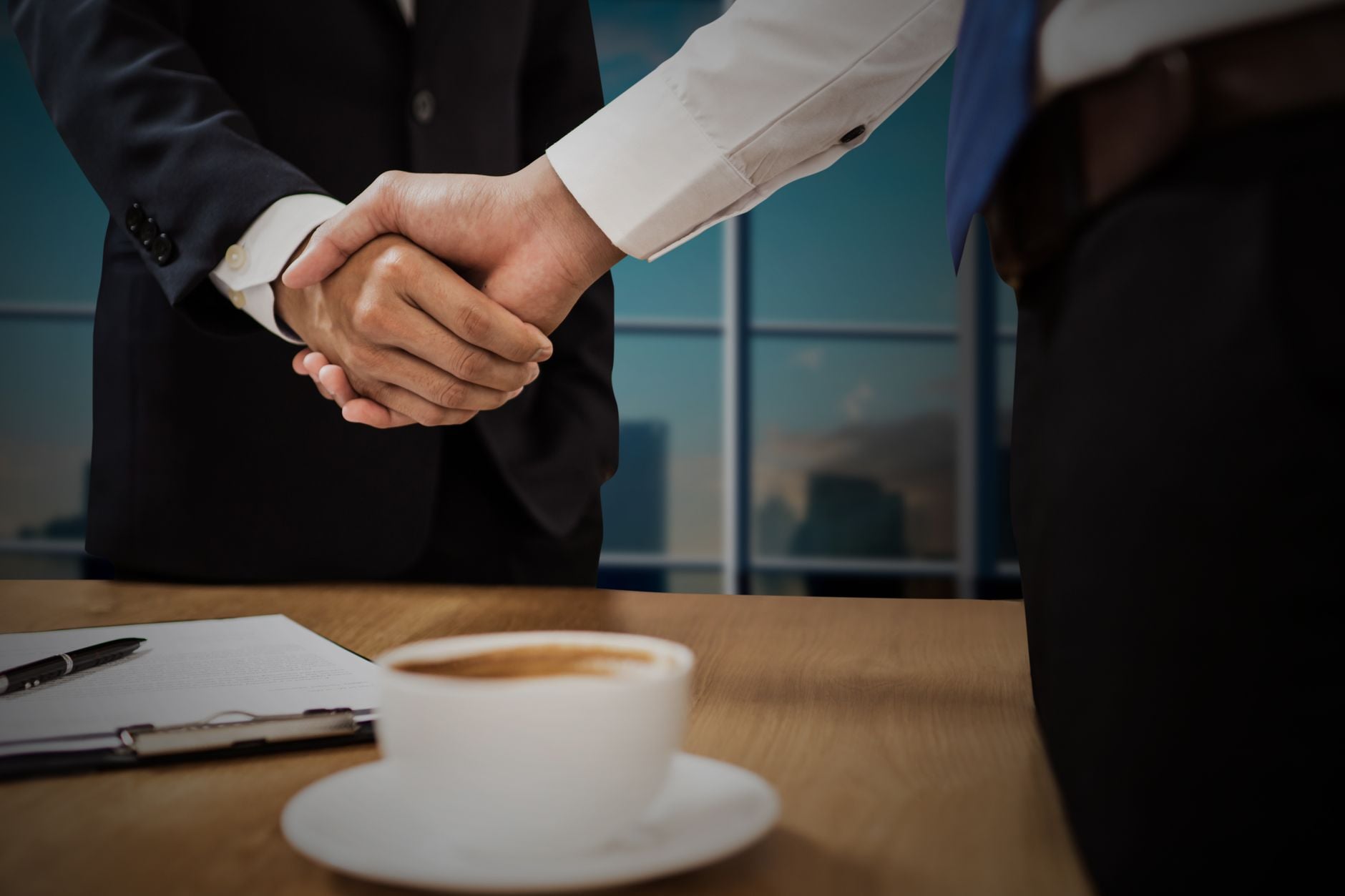 B2B Go-to-Market Strategy: ICP, Offer, and Channel Fit 1 Two professionals shaking hands across a desk with cityscape in the background.