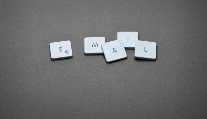 Close-up of the word 'email' formed with letter tiles on a gray surface.