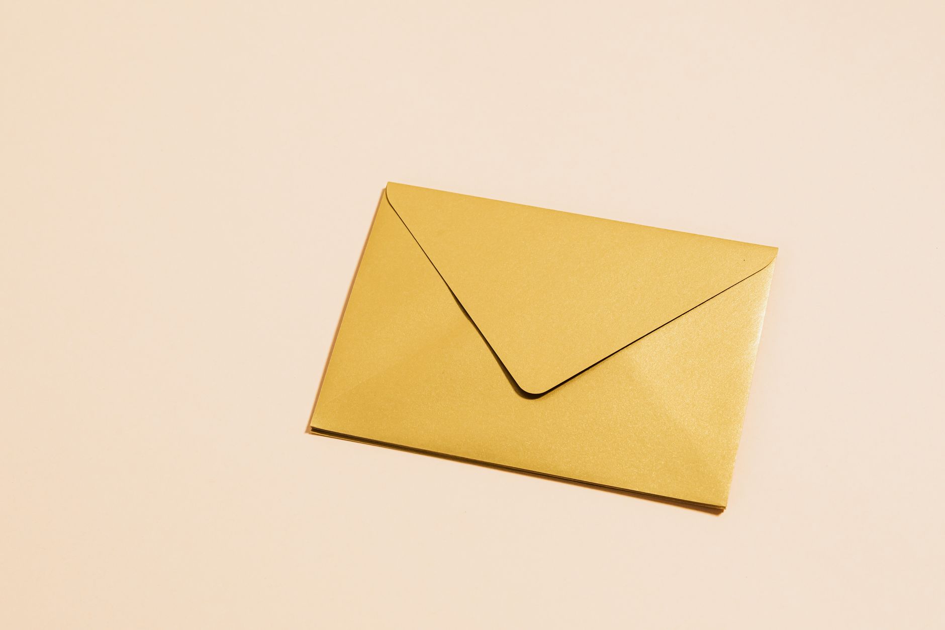 B2B Email Subject Lines: Open Rates Without Clickbait 1 A sleek gold envelope placed on a vibrant yellow background, perfect for postal themes.