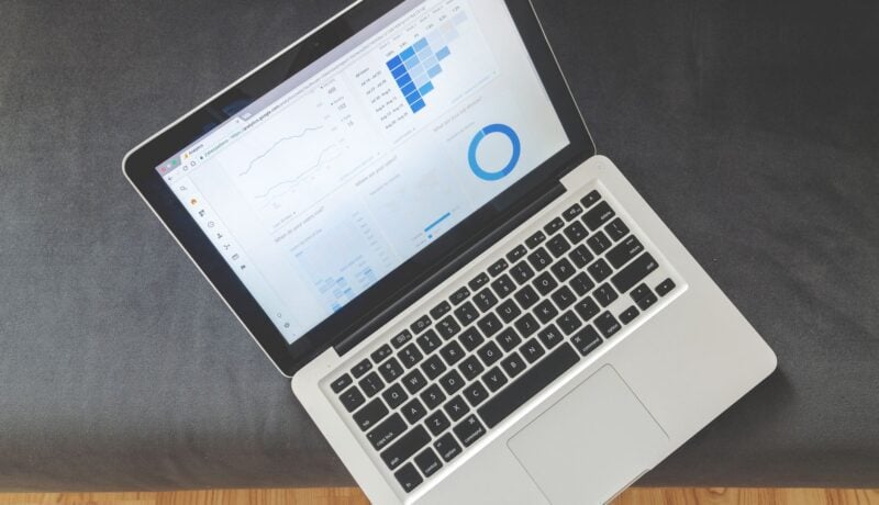 Overhead view of a laptop showing data visualizations and charts on its screen.