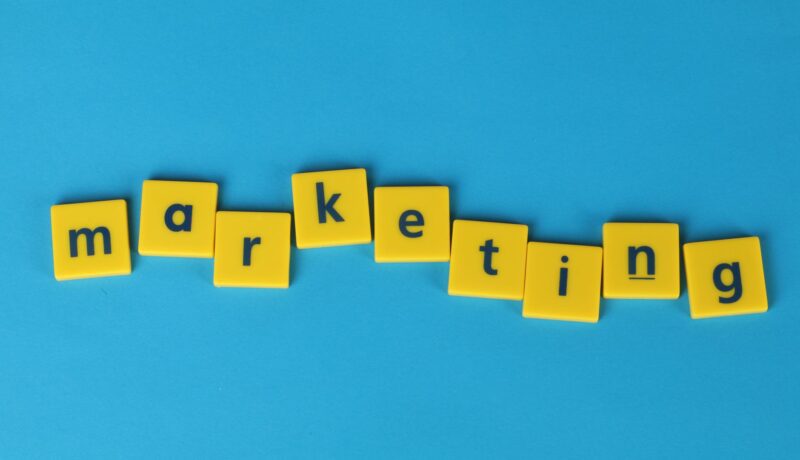 Bright yellow tiles spelling 'marketing' on a blue background, ideal for business themes.