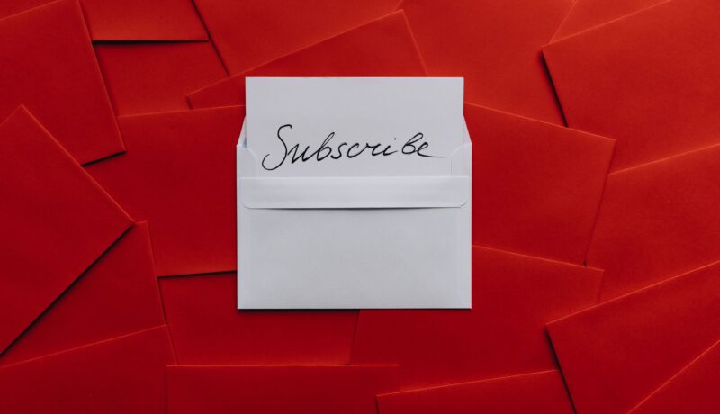 A collection of red envelopes with a central white envelope containing a subscribe card. Perfect for marketing themes.