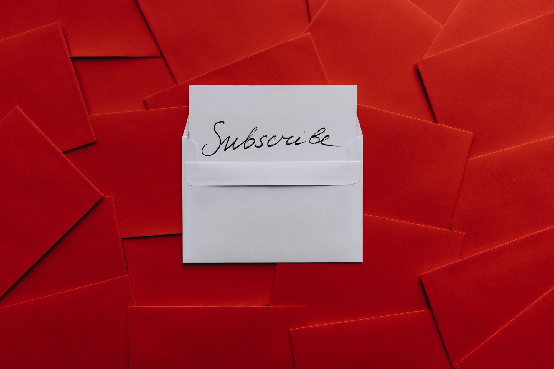 Newsletter Lead Generation: Build Audience and Pipeline Together 1 A collection of red envelopes with a central white envelope containing a subscribe card. Perfect for marketing themes.
