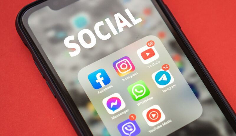 Close-up of a smartphone showing popular social media apps on screen.