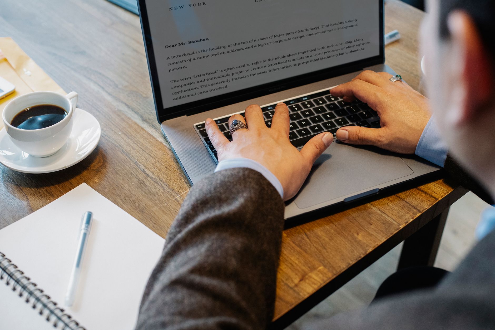 Brand Messaging Framework: Say One Clear Thing That Converts 1 Crop faceless male entrepreneur in formal wear sitting at table with cup of coffee and notebook while working on project in laptop