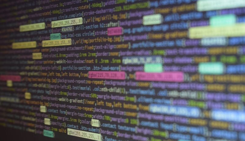 Close-up of colorful source code on a monitor, showcasing programming and technology concepts.